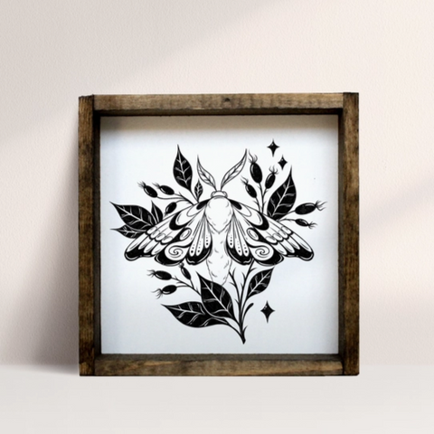 Framed artwork of a black butterfly design on a white background