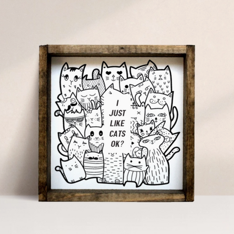 Framed artwork with black and white cat illustrations on a beige background