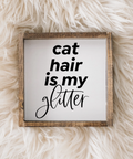 Framed sign with 'cat hair is my glitter' text on a fluffy white surface