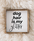 Framed sign with 'dog hair is my glitter' text on a fluffy white surface