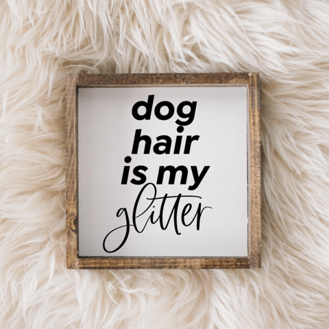 Framed sign with 'dog hair is my glitter' text on a fluffy white surface