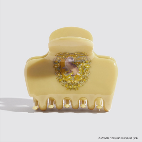 Decorative beige hair clip with a bird and floral design on a light gray background