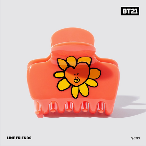 Orange hair clip with a cartoon flower design on a white background, featuring the BT21 brand.