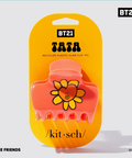 Pink claw clip with yellow flower design on a yellow packaging with BT21 branding.