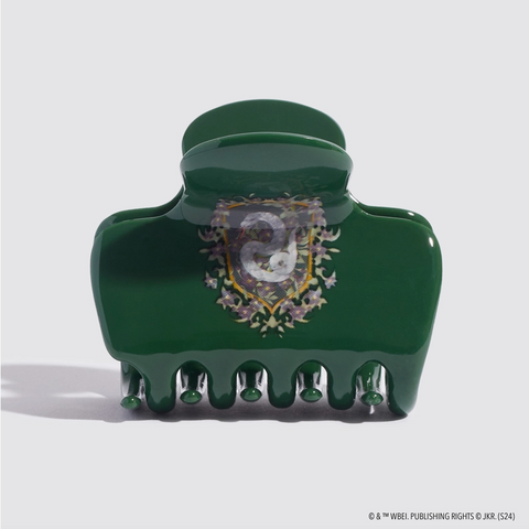Green hair clip with decorative emblem on a white background