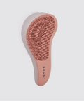 Pink hairbrush with bristle head on a light gray background
