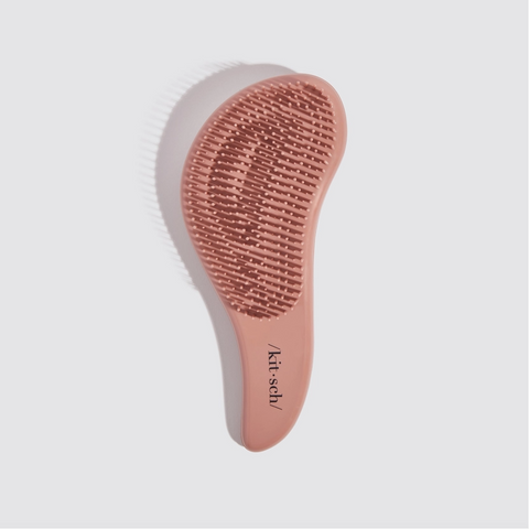 Pink hairbrush with bristle head on a light gray background