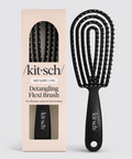 Black detangling flexi brush with packaging on a light gray background