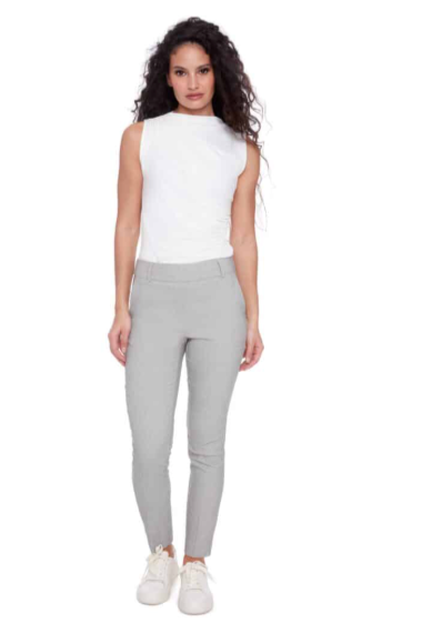Woman wearing a white sleeveless top and gray leggings on a white background