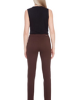 Woman wearing a black sleeveless top and brown pants on a white background