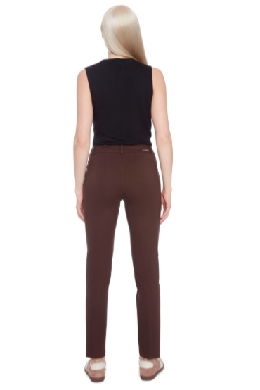 Woman wearing a black sleeveless top and brown pants on a white background