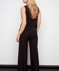 Woman wearing a black jumpsuit against a white background
