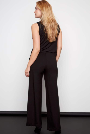 Woman wearing a black jumpsuit against a white background