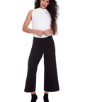 Woman wearing a white top and black high-waisted pants on a white background