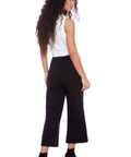 Woman wearing a white top and black high-waisted pants on a white background
