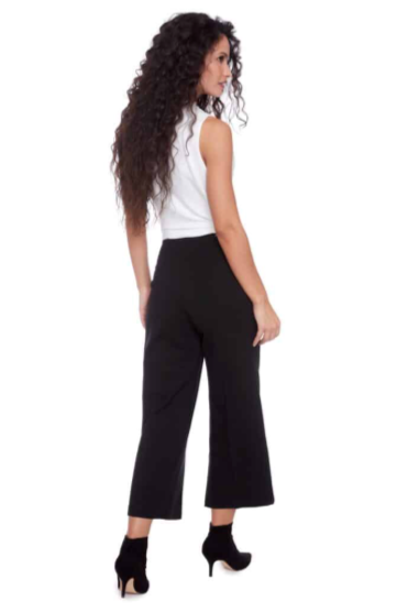 Woman wearing a white top and black high-waisted pants on a white background