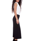 Woman wearing a white sleeveless top and black skirt on a white background