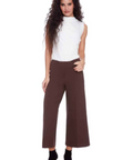 Woman wearing a white sleeveless top and brown pants on a white background with 'i love tyler madison' text.