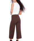 Woman wearing a white top and brown pants on a white background