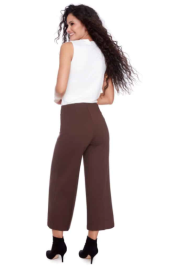 Woman wearing a white top and brown pants on a white background