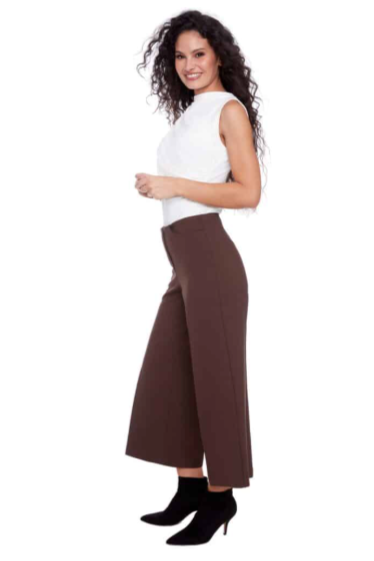 Woman wearing a white top and brown wide-leg pants on a white background