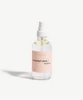 Clear spray bottle with a pink label on a white background