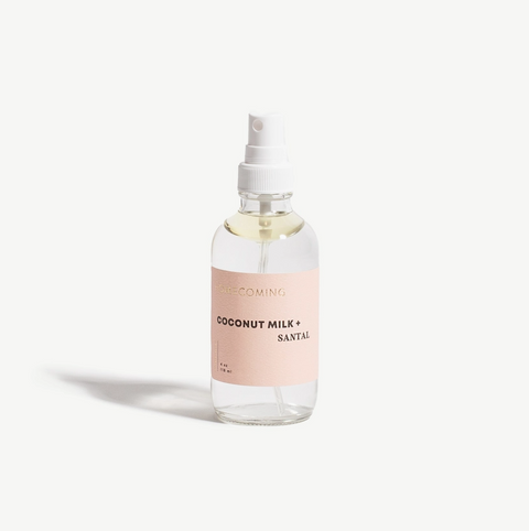 Clear spray bottle with a pink label on a white background