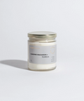 Candle jar labeled 'Almond Macaron Vanilla' on a light gray background