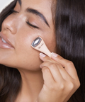 Woman applying a cosmetic product to her face with a brush
