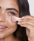 Woman applying makeup with a brush to her face