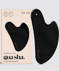 Black gua sha tool with packaging on a light gray background