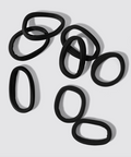 Set of black hair ties on a light gray background