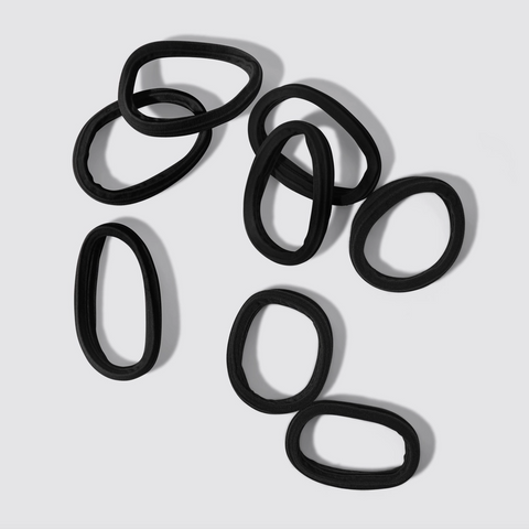 Set of black hair ties on a light gray background