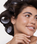 Woman with hair in rollers against a white background