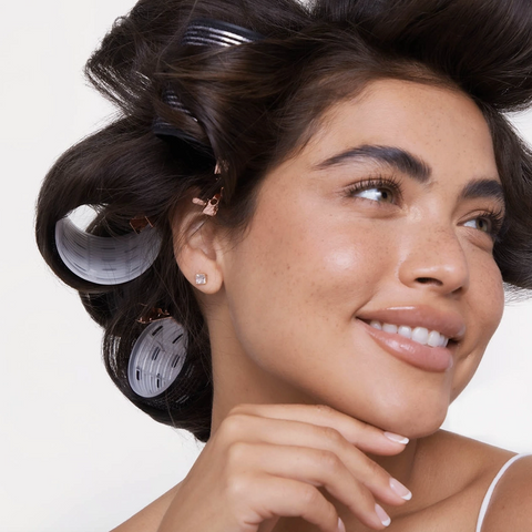 Woman with hair in rollers against a white background