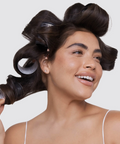 Woman with hair in rollers against a white background