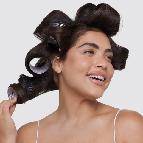 Woman with hair in rollers against a white background