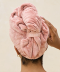 Person wearing a pink towel on their head with 'kitsu' branding.