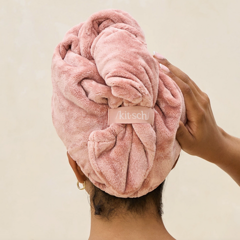 Person wearing a pink towel on their head with 'kitsu' branding.