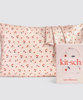 Satin pillowcase with cherry pattern and 'kit-sch' packaging on a light gray background