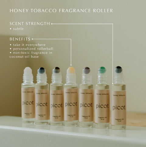 Row of picot honey tobacco fragrance roller bottles on a neutral background with product details.
