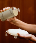 Person holding a bottle labeled 'picot' and a white pad against a brown background