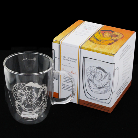 Clear glass mug with engraved design next to its packaging box on a black background