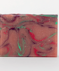 Swirled soap bar with red and green colors on a white background