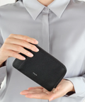 Person holding a black wallet with product details on the right side