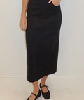 Person wearing a black skirt with a white background