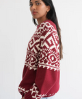 Woman wearing a red and white patterned sweater on a white background