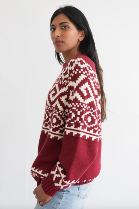 Woman wearing a red and white patterned sweater on a white background