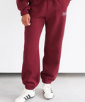 Maroon tracksuit with white text on a plain background