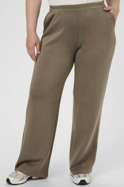 Brown pants worn by a person on a white background